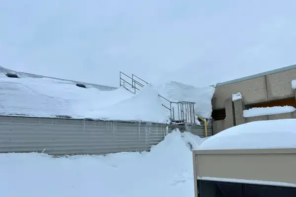 Plan rapproché d'une accumulation importante de neige sur un une toiture.